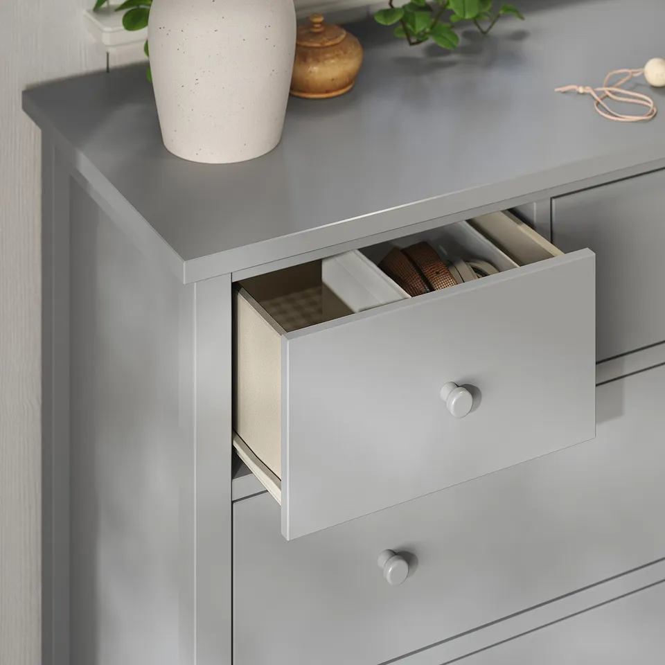 Grey chest of drawers with wooden knobs, one drawer open revealing compartments, quality craftsmanship.