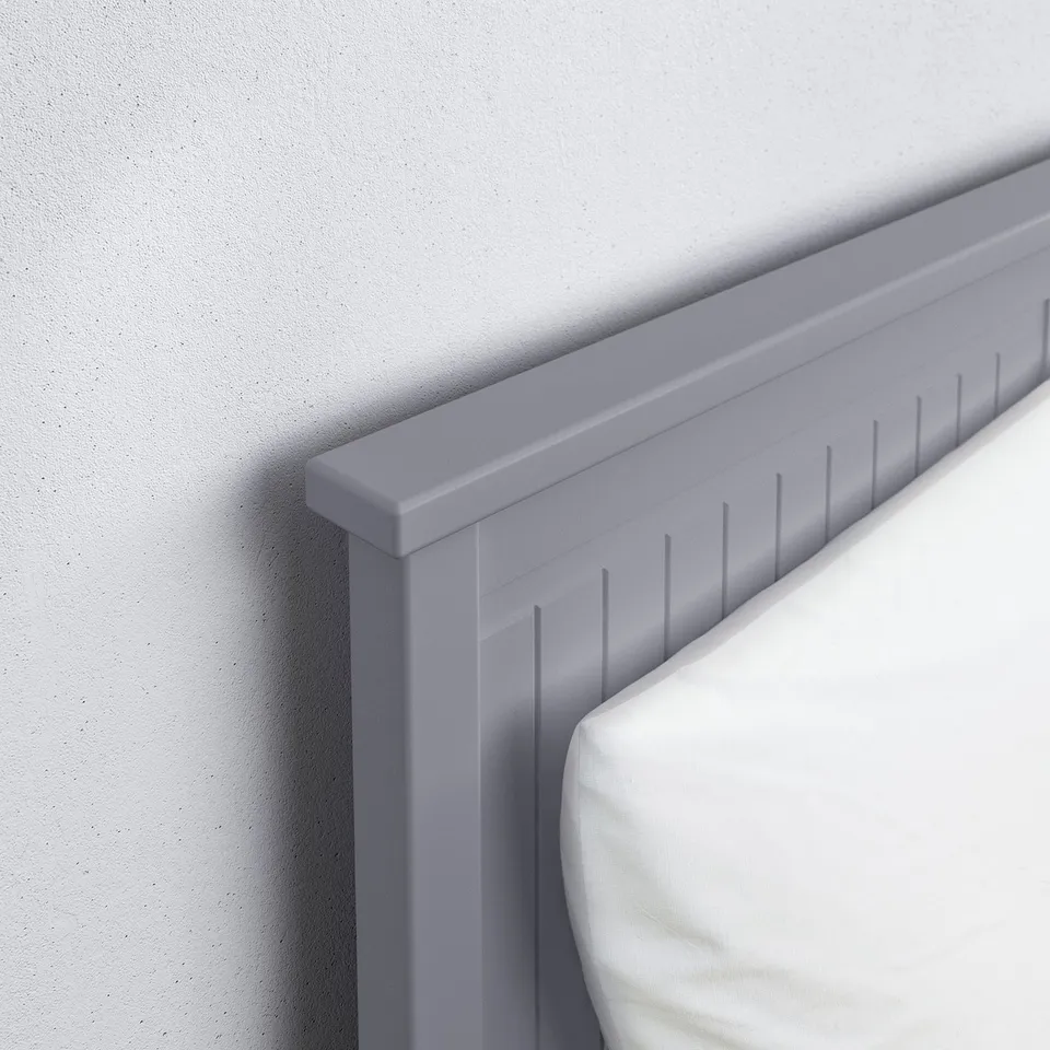 Grey-blue modern bed frame, sleek & sturdy against plain wall.