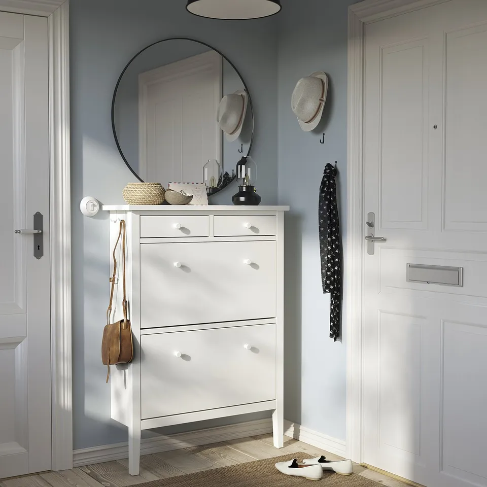 Entryway with white GULLABERG shoe cabinet, 2 drawers, 14-pair shoe storage, round mirror, wall hooks, blue wall, wooden floor.