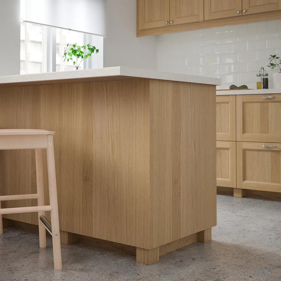 Wooden cabinets, light oak, uniform design. Spacious central island dominates the kitchen.
