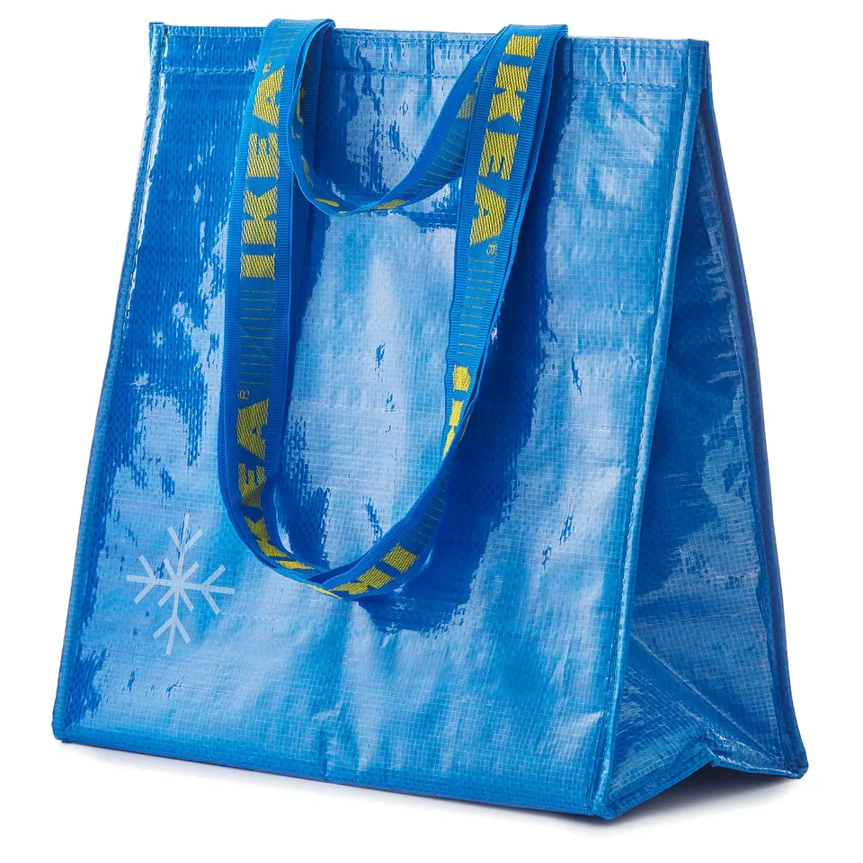 Blue FRAKTA bag, textured, with yellow handle patterns, stands upright with two handles.