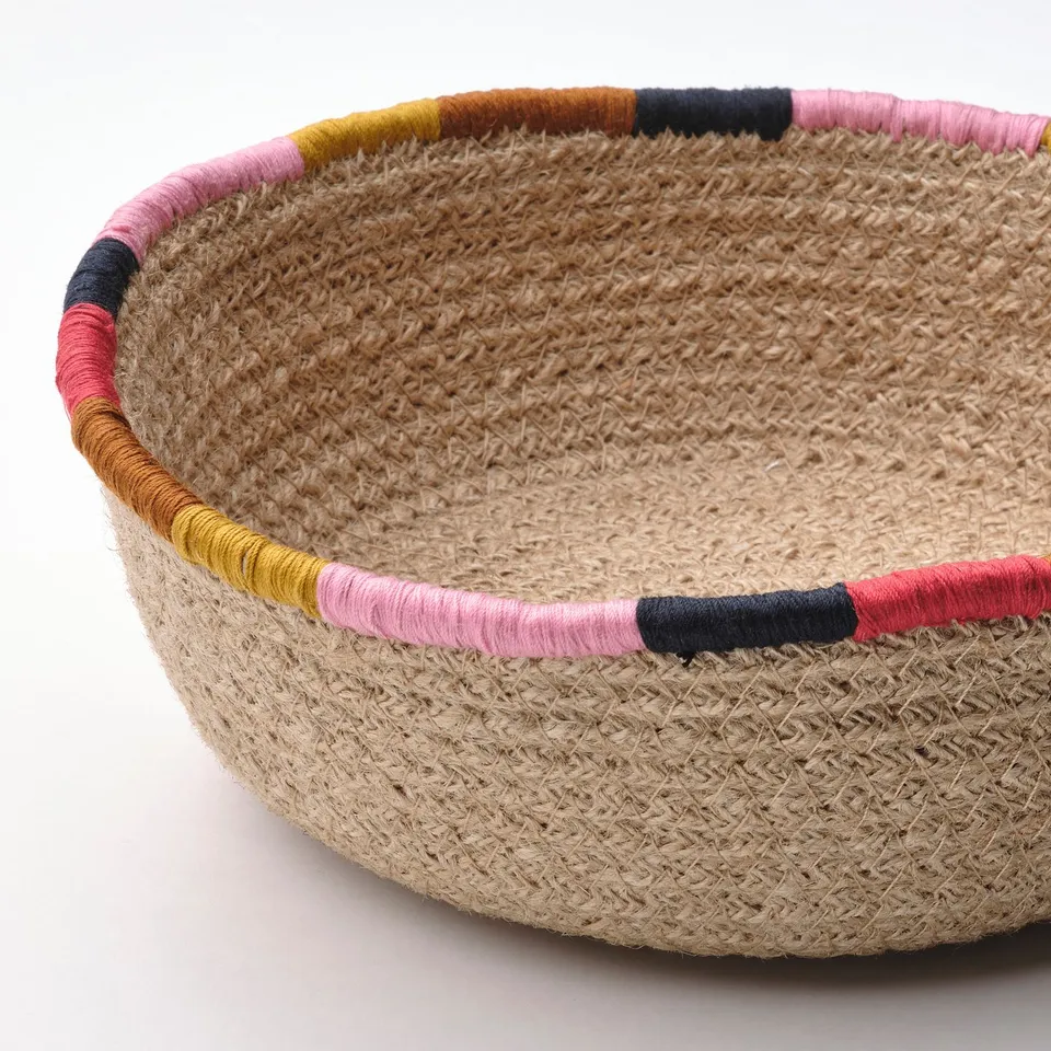 Handcrafted basket with colourful embroidered edges. Made from durable jute, showcasing natural textures and vibrant accents.