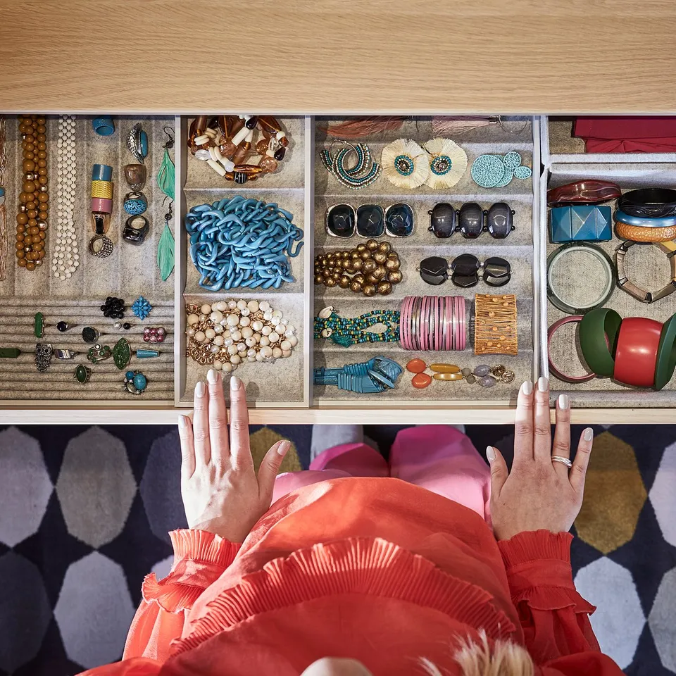 Open jewellery drawer with varied accessories organised in compartments.