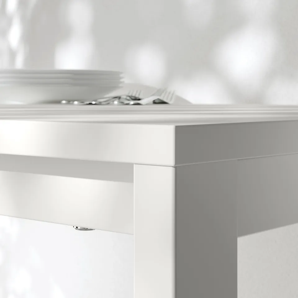 Close-up of a clean, modern table. White melamine top and sturdy edges visible.