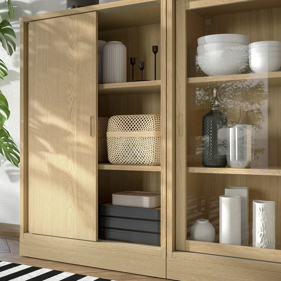 Modern wooden cabinet with sliding door showing decorative items and adjustable shelves.