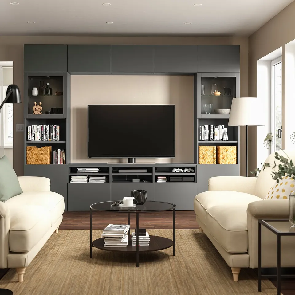 Modern living room with grey BESTÅ tv unit, white sofas, glass coffee table, and beige rug.