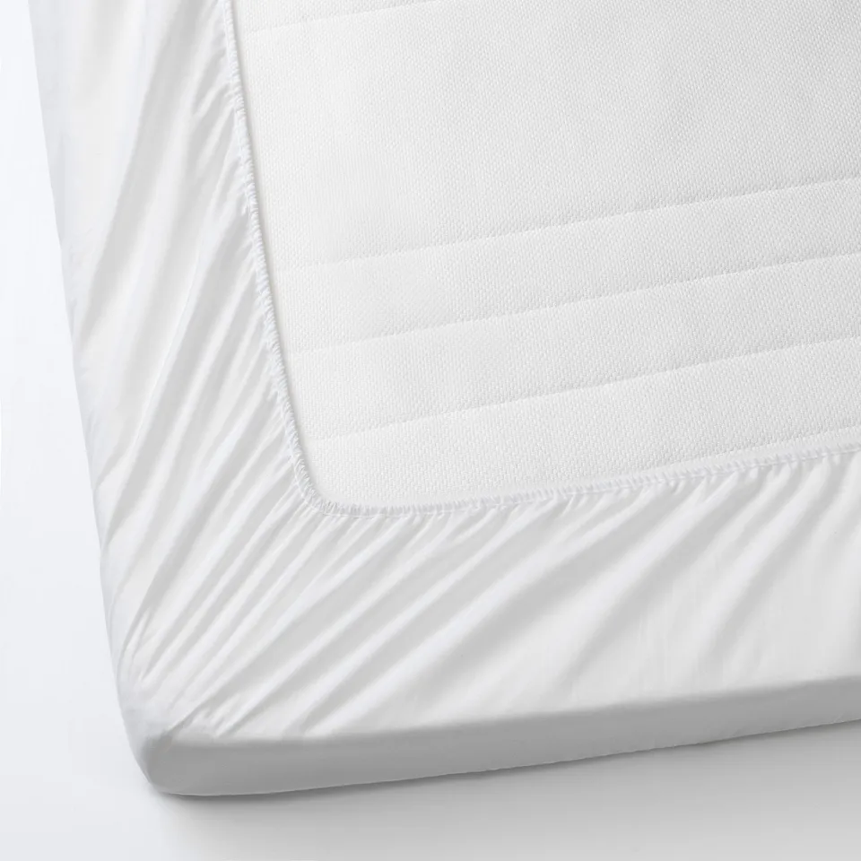 White mattress protector for babies bed, waterproof, fits snugly.