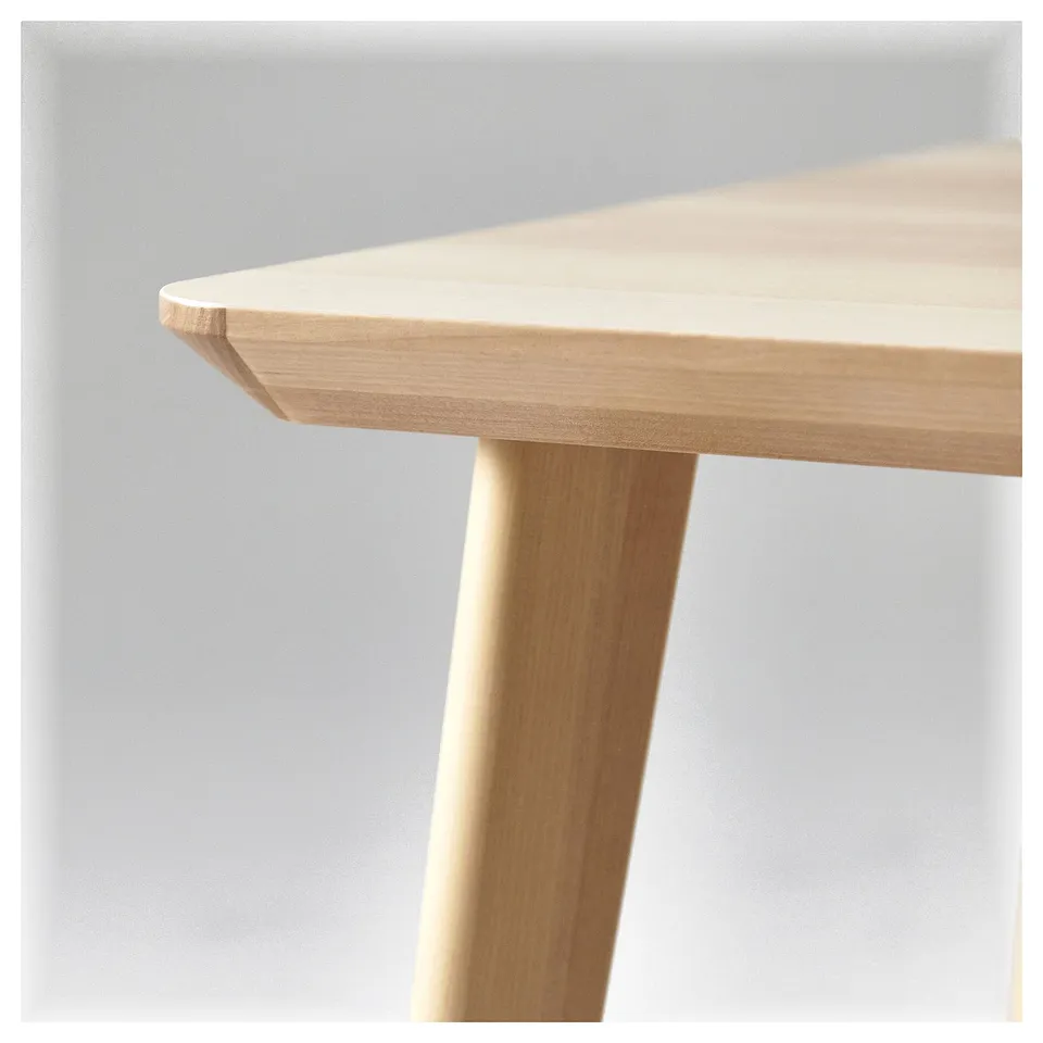 Light wood table close-up, light brown, rectangular top, rounded edge, simple design.
