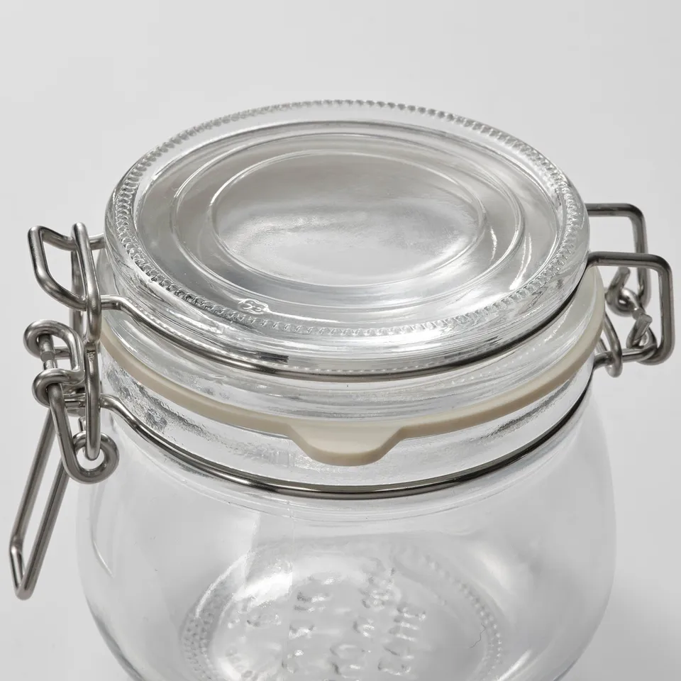 Clear glass jar with secure metal clasp lid, sealed rubber band for airtight storage.