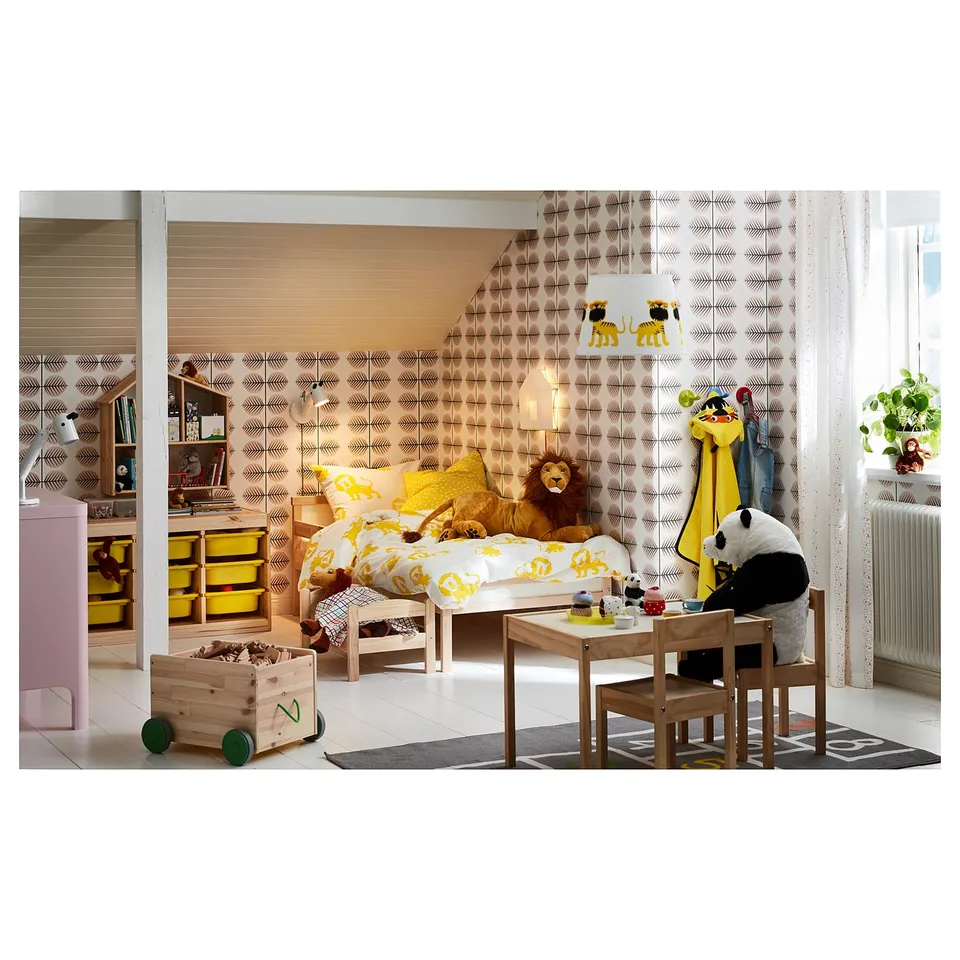 Cosy kids room with beech SNIGLAR bed, yellow linens, stuffed animals, and colourful decor.