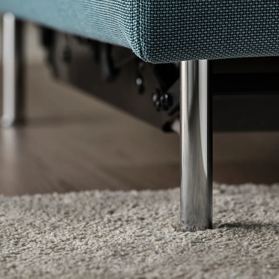 Modern sofa with metal legs; deep, textured blue cushion.