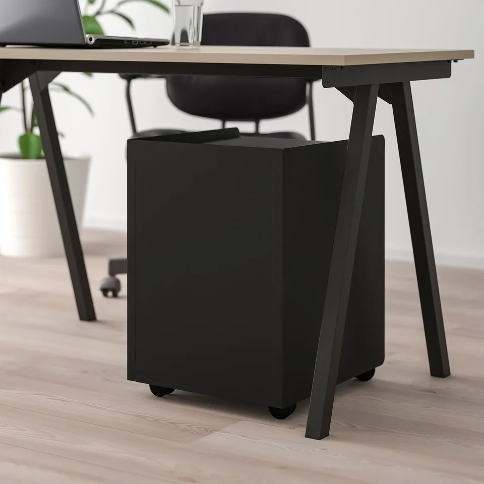 Black office chair with castors under a modern desk on wooden floor.