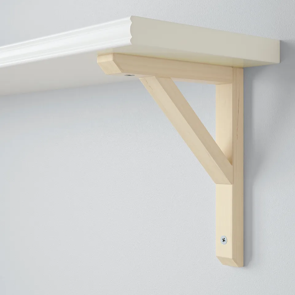 Light wooden wall shelf with angled bracket, securely mounted on a white wall. Robust, minimalist design.