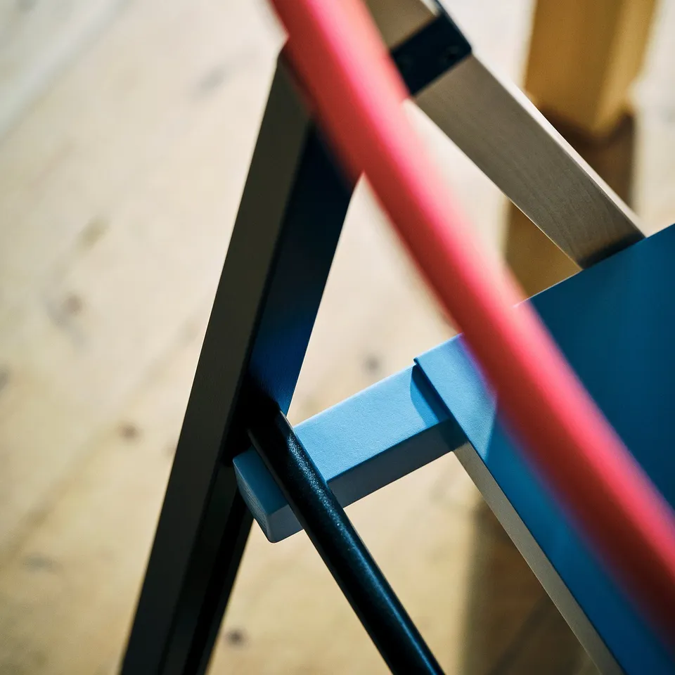 Vibrant, multi-colored chair legs in red, blue, and black; showcasing high-quality craftsmanship and stylish design.
