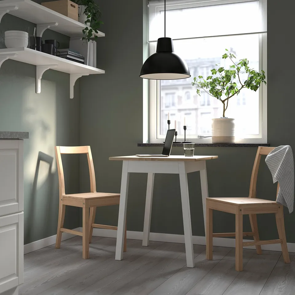Cosy kitchen nook with PINNTORP table, laptops, and decor.