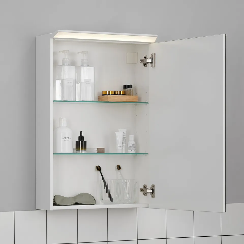 White mirror cabinet with led light stores toiletries. Two glass shelves, doors open 110°. Safety film on back.