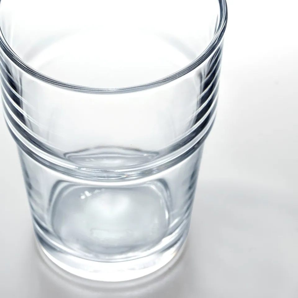 Top-down view of a clear, transparent glass with horizontal grooves, likely made of durable glass material.