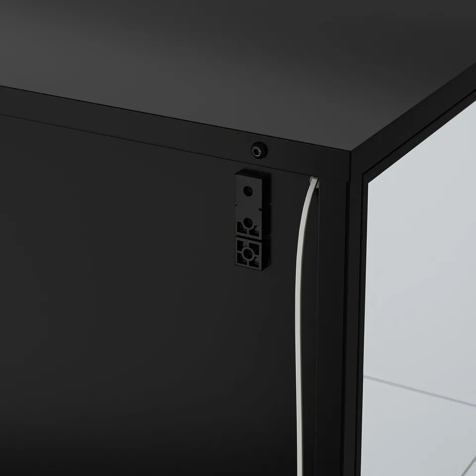 Modern black cabinet with glass door, cable management, integrated light.