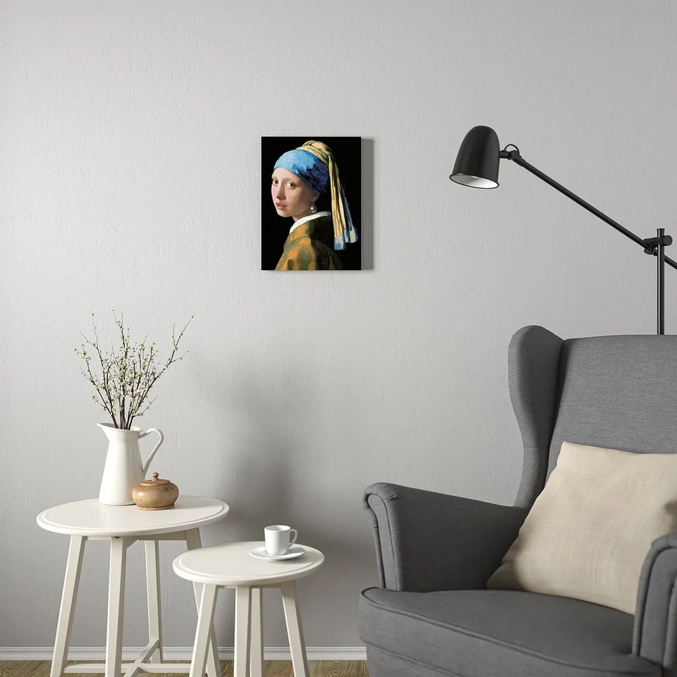 Minimalist living room with PJÄTTERYD art, chair, tables, and lamp.