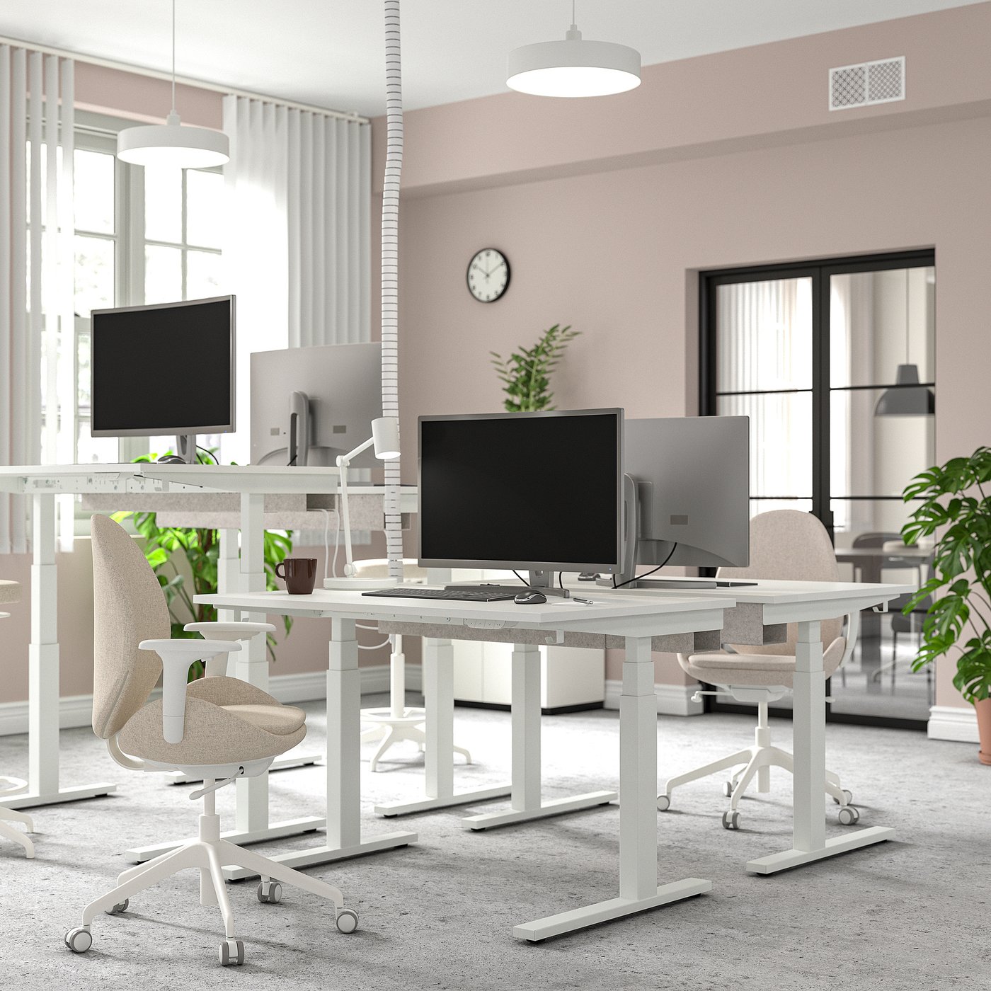 Modern office with MITTZON sit-stand desks, dual monitors, ergonomic chairs, large windows, and pendant lamps. Pink walls, ample legroom.