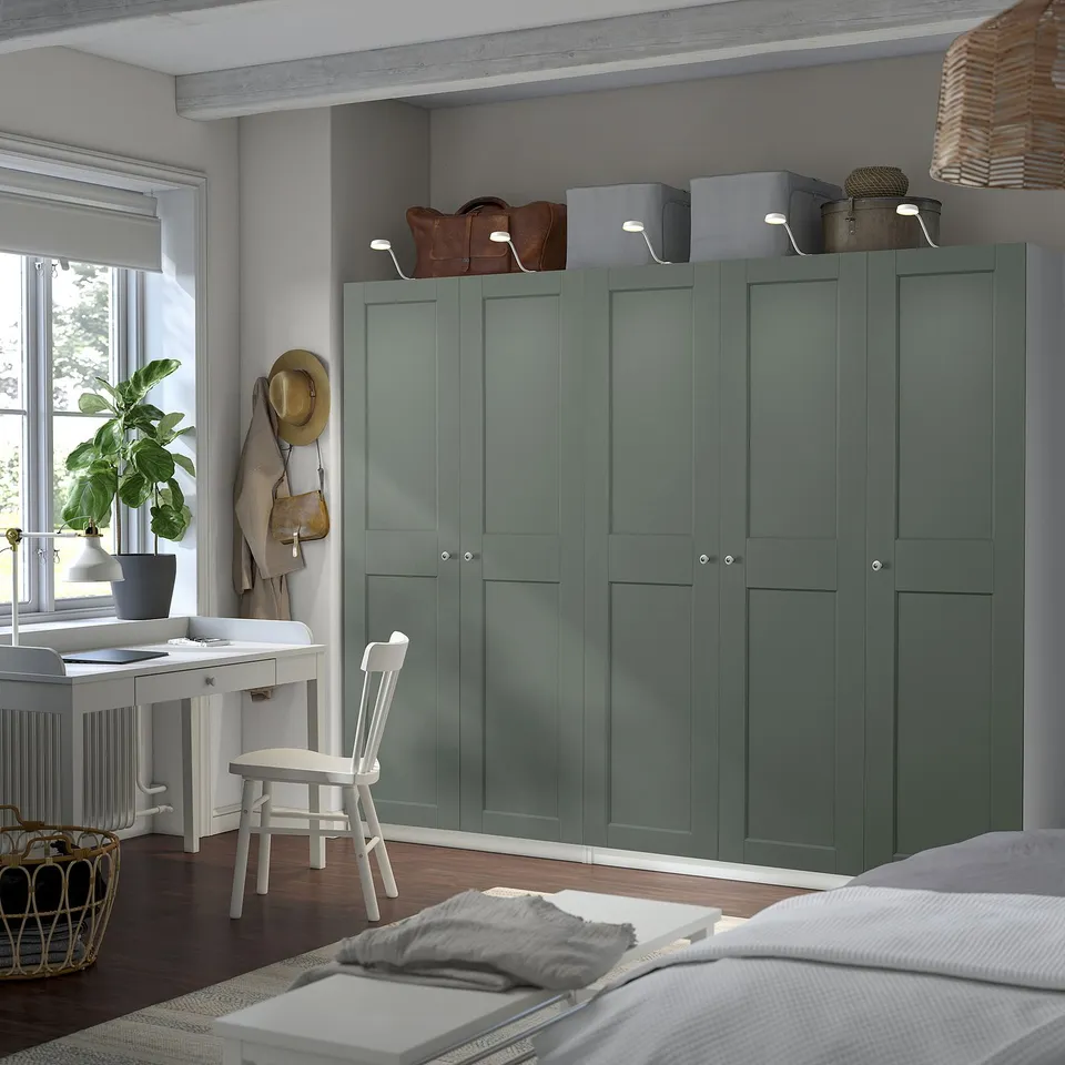 Green PAX wardrobe near white desk in organised room.