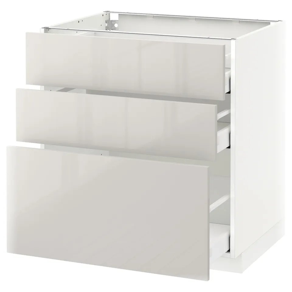 Modern white METOD kitchen cabinet with three open drawers.