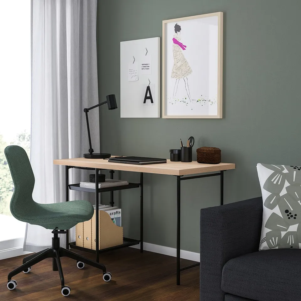Home office with LAGKAPTEN desk, green wall, art, green chair, lamp, sofa.