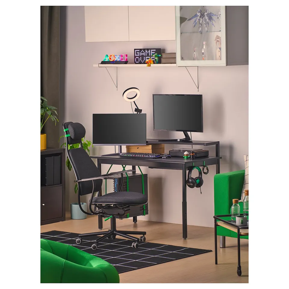 Home office with black LÖPARBANA chair, dual monitors, green sofa.