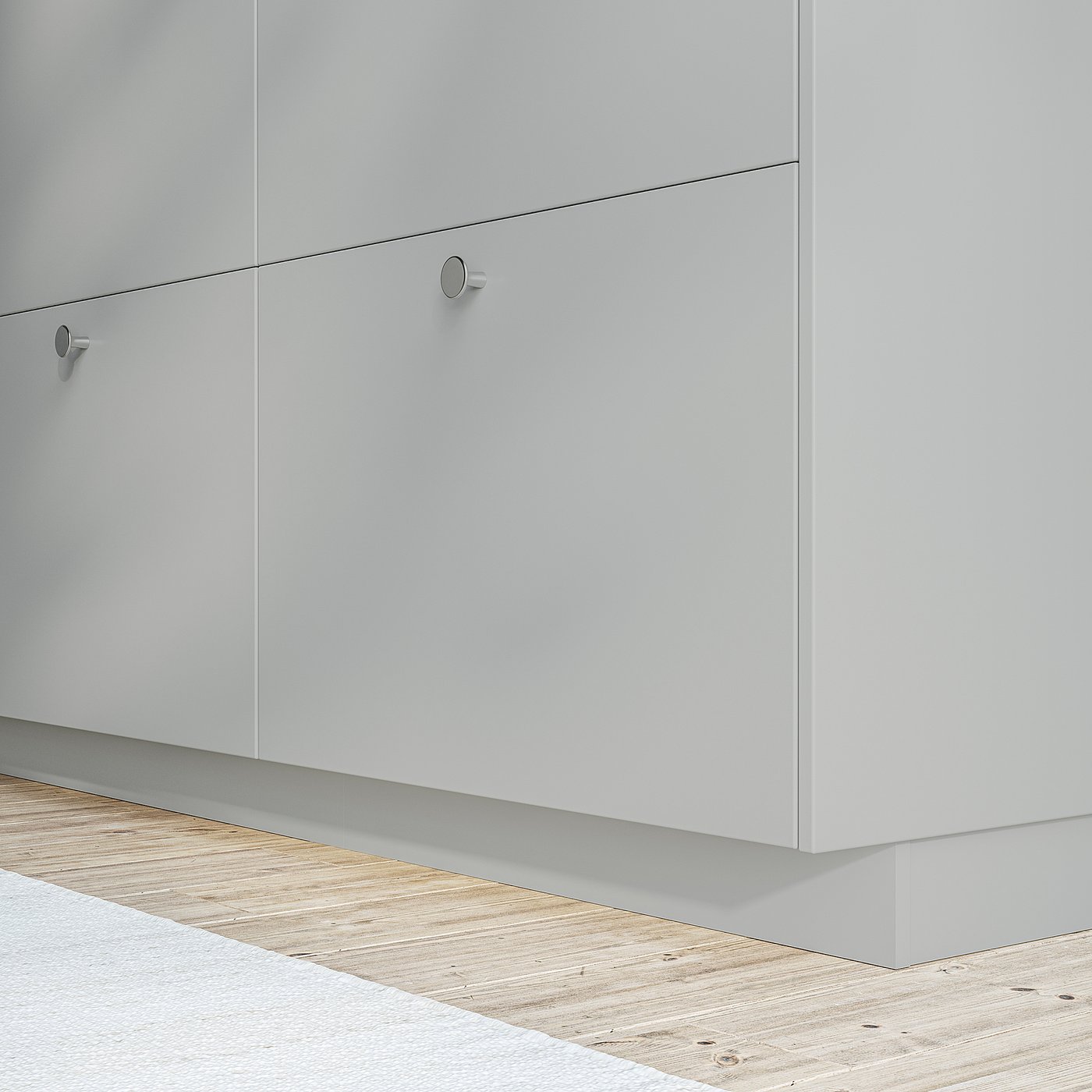 White kitchen cabinets with sleek, round handles attached to a light wooden floor. The cabinets appear smooth and modern, providing storage space.