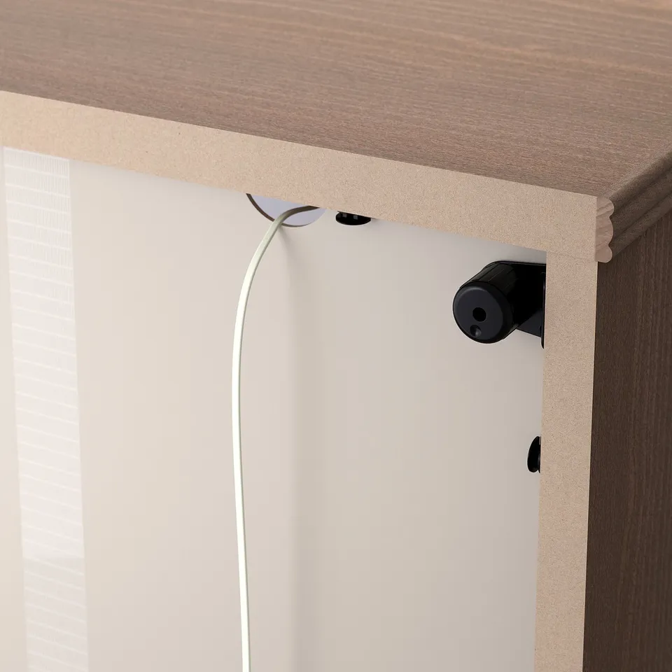 Cord management clip on back of storage unit, keeping cables tidy.