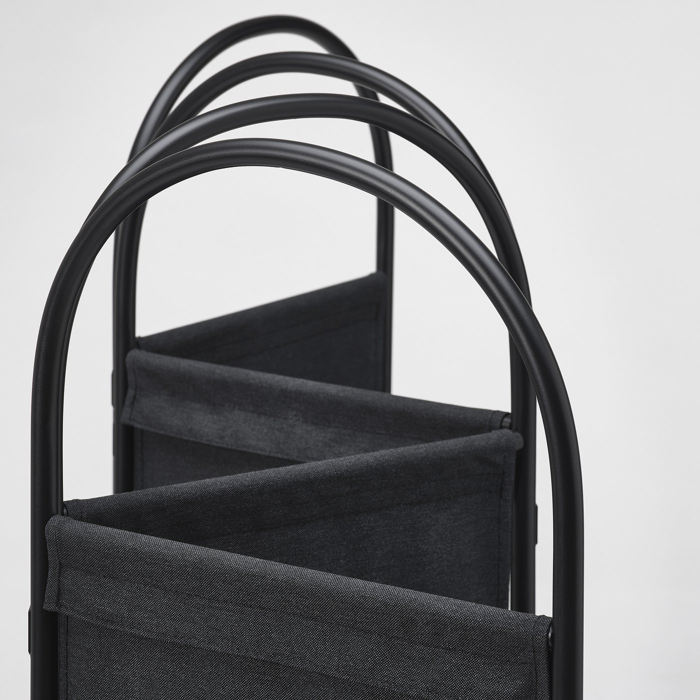 Black metal-framed room divider with sturdy, folded fabric panels. Modern, industrial design with clean lines.