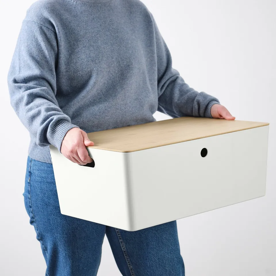 Person holding a white KUGGIS box with a lid, suitable for dust protection and stacking, made from bamboo.