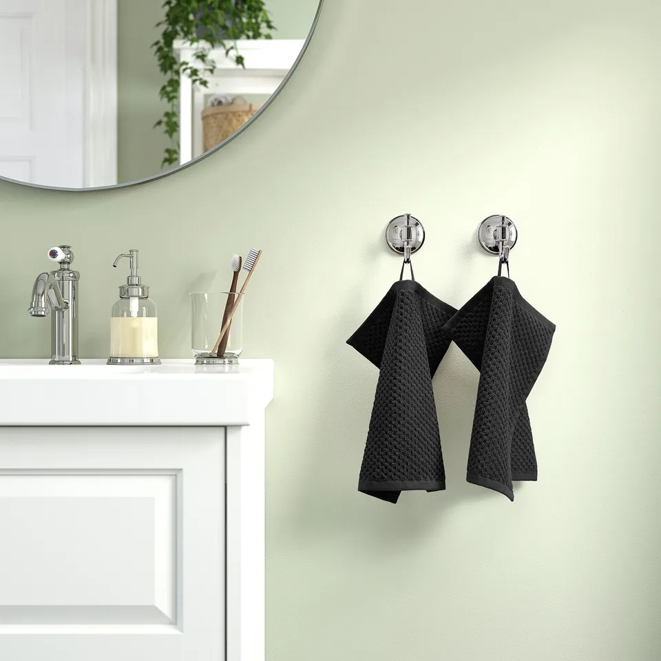 Modern bathroom with white sink, chrome details, and GULVIAL towels on hooks.