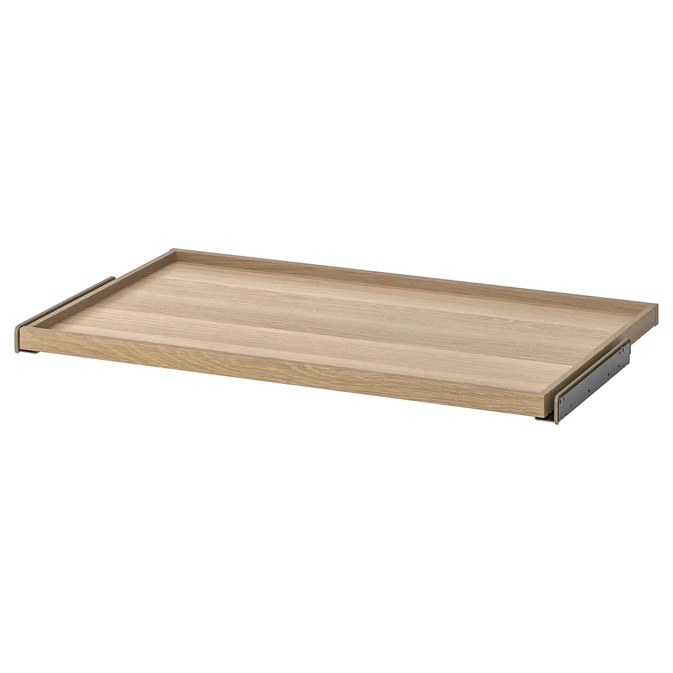 An ikea KOMPLEMENT pull-out tray in light oak color, designed for wardrobe storage, with a wooden and metal design.
