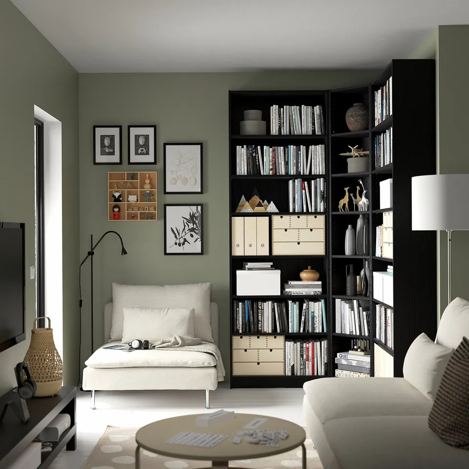 Modern living room with green BILLY bookcase, white couch, coffee table, and wall art.