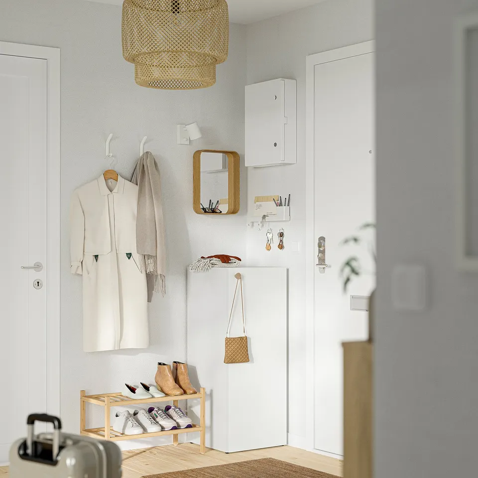 Minimalist entryway with shoe rack, wall mirror, & hooks.