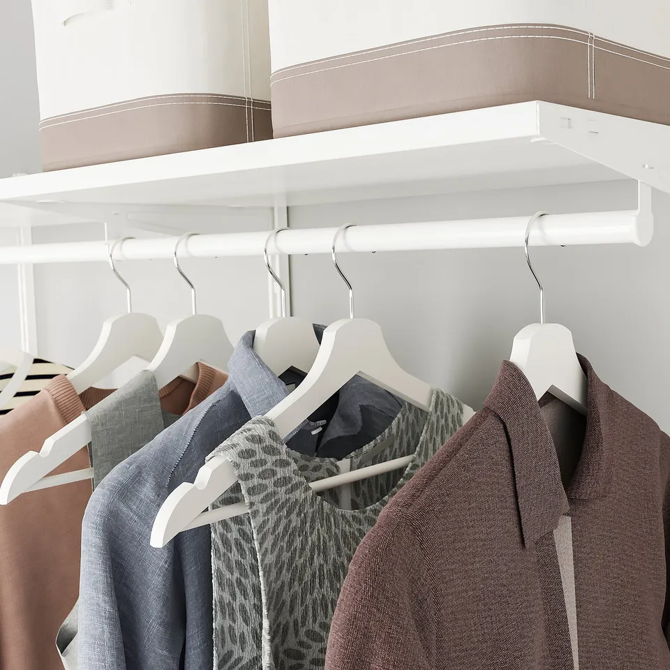 Neatly organised closet with hangers and storage boxes.