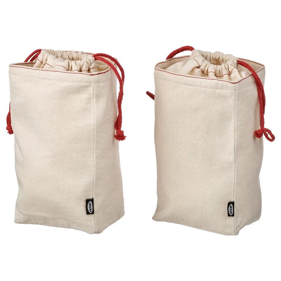 Pair of beige GULLRISMOTT beige cloth bags with red cords for storage.