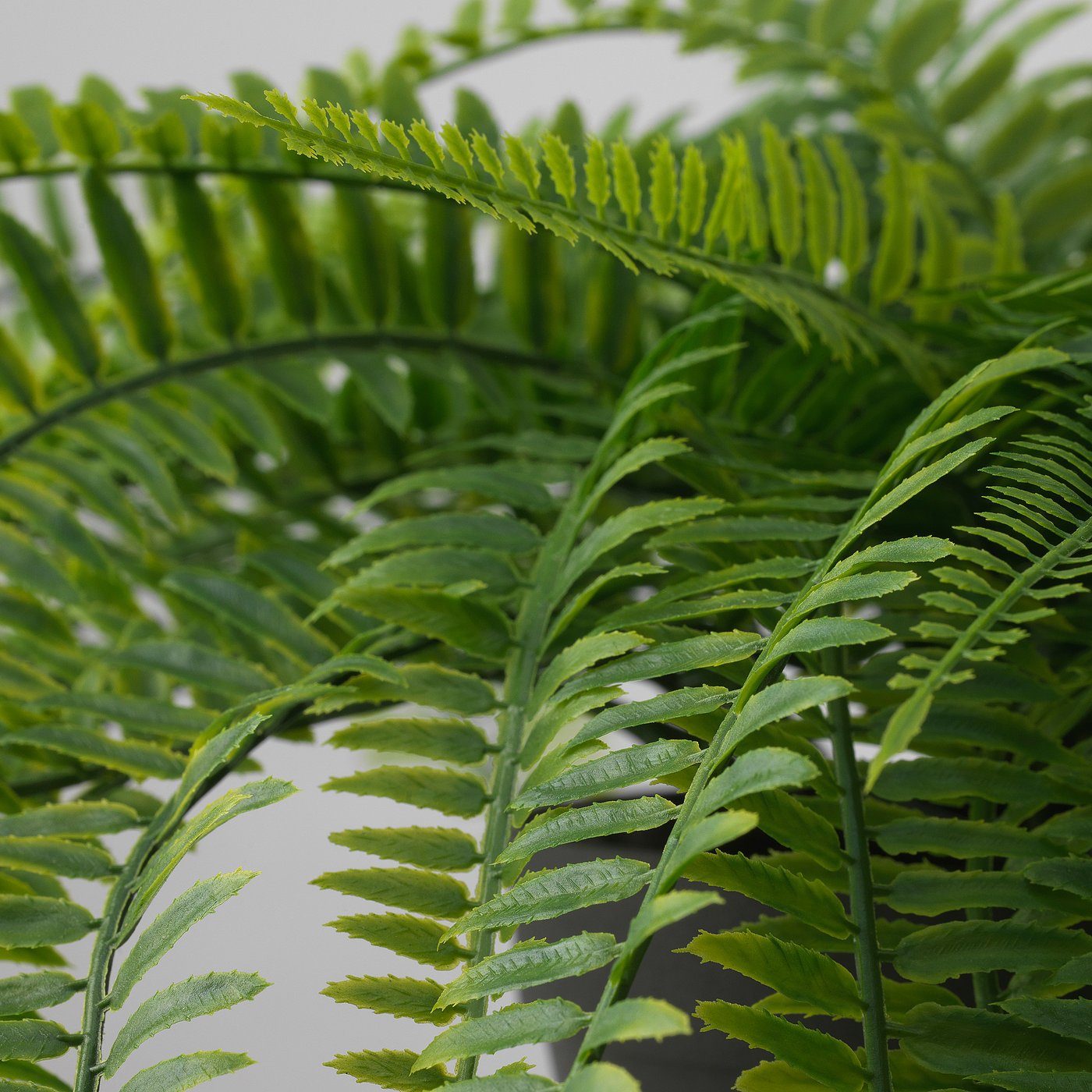 Lifelike artificial fern with vibrant green, finely detailed fronds.