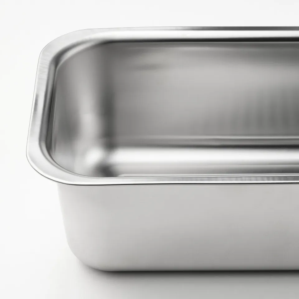 Shiny, high-quality stainless steel bread loaf pan, reflecting light, with even surface for baking.