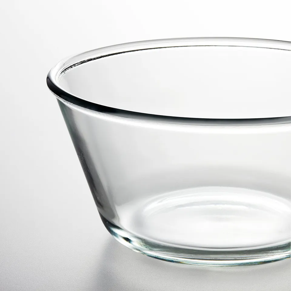 Clear glass bowl with smooth, rounded edges, placed on a white surface.