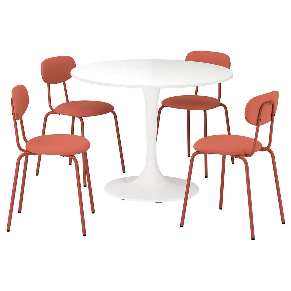Modern dining set: round white table, four orange chairs with metal frames.