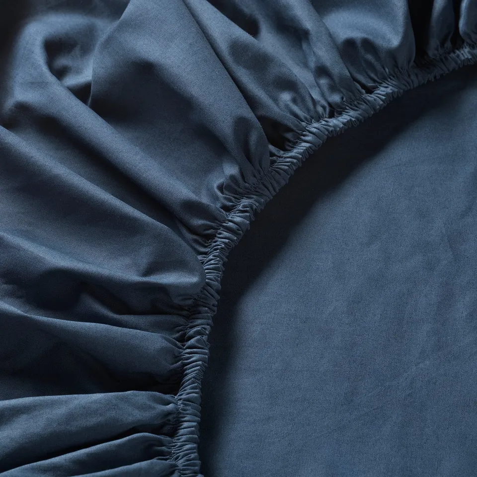 Dark blue fabric close-up, showcasing smooth texture and tight stitching, highlighting high-quality, soft percale weave.