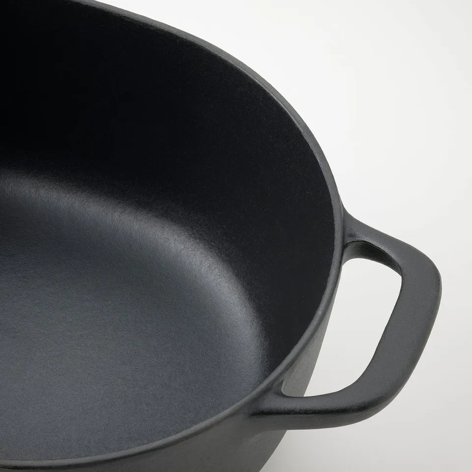 Black cast iron pan with smooth, even interior surface and sturdy handle, perfect for cooking.