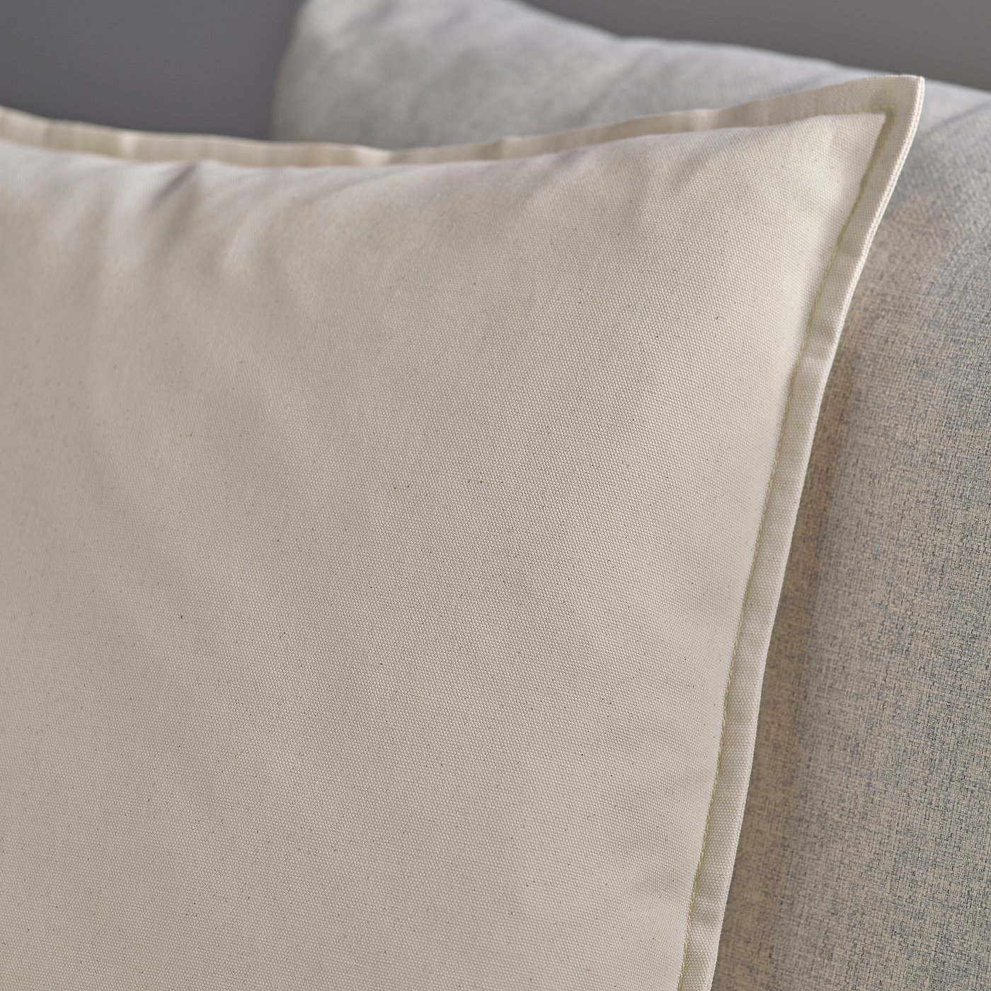 Close-up of GURLI cushion cover in soft, recycled cotton, showcasing smooth fabric and neat stitching.