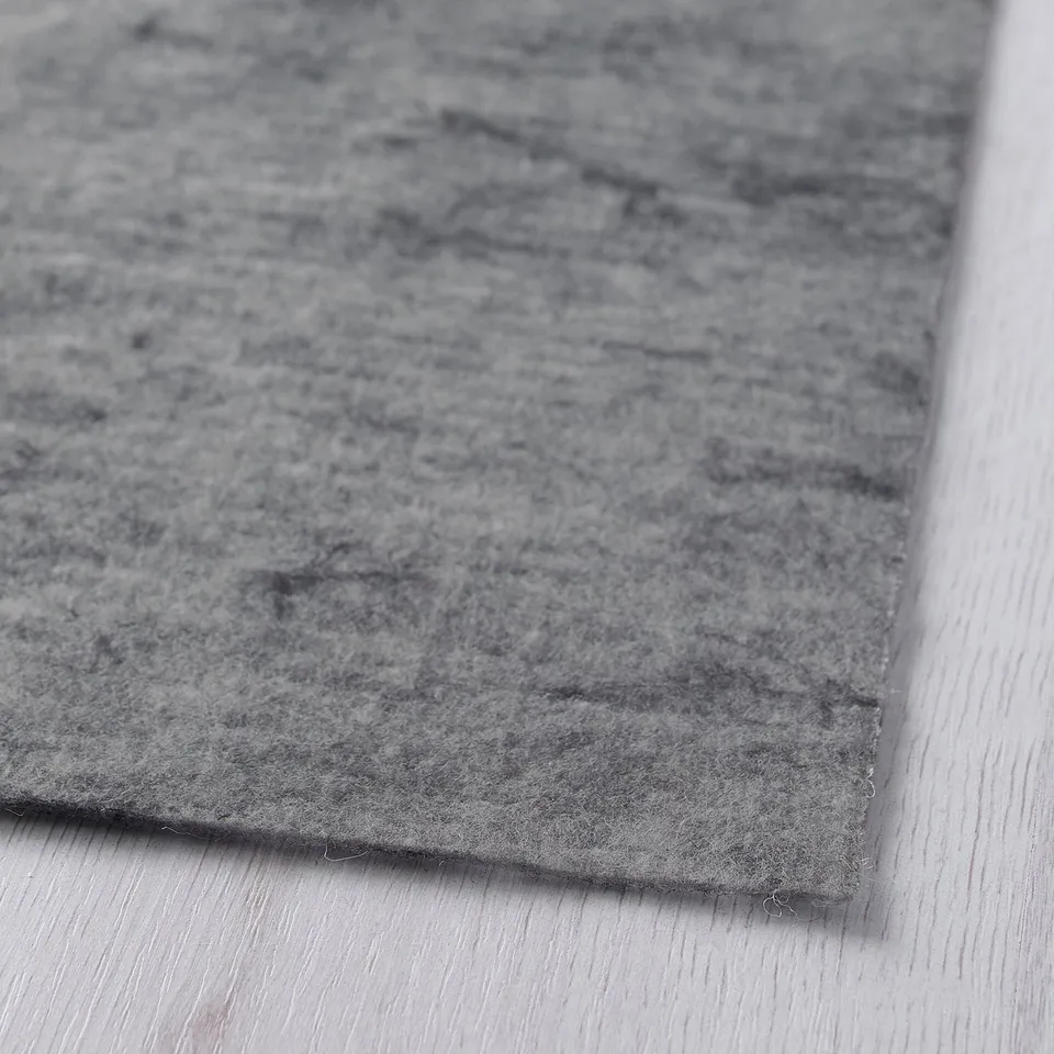 Grey rug pad, close-up, protects floors, stabilises rugs.