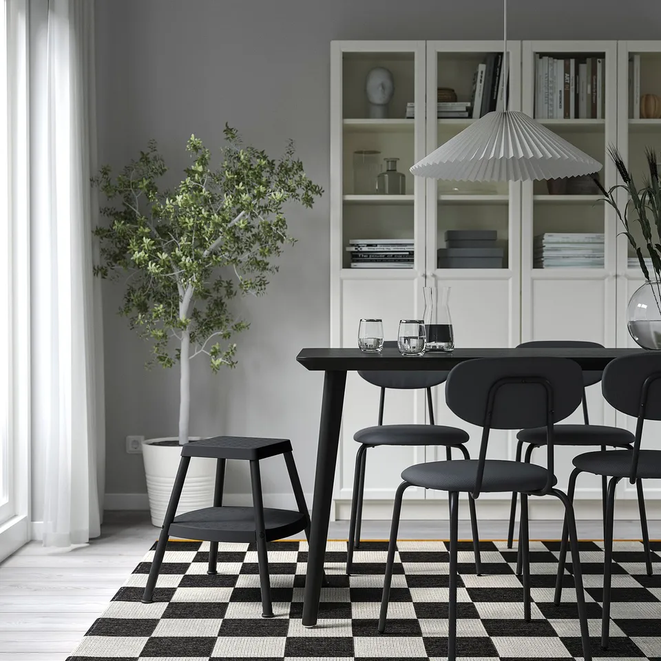 Modern dining room with HADDARP stool, chairs, table, and plant.