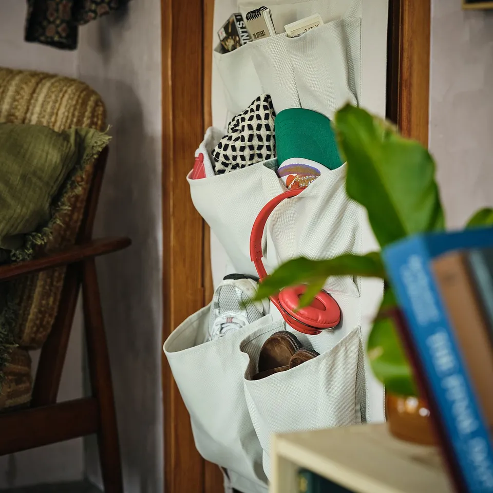 White door hanger organiser with compartments and hooks for shoes, bags, and small items.