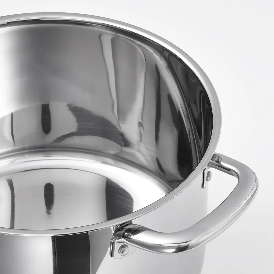 Close-up of stainless steel pots polished inner surface and sturdy handle.
