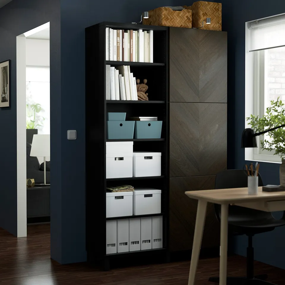Modern office with BESTÅ shelves, wooden table, and lamp.